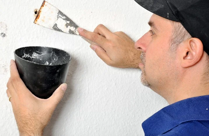 Person spachtelt Wand